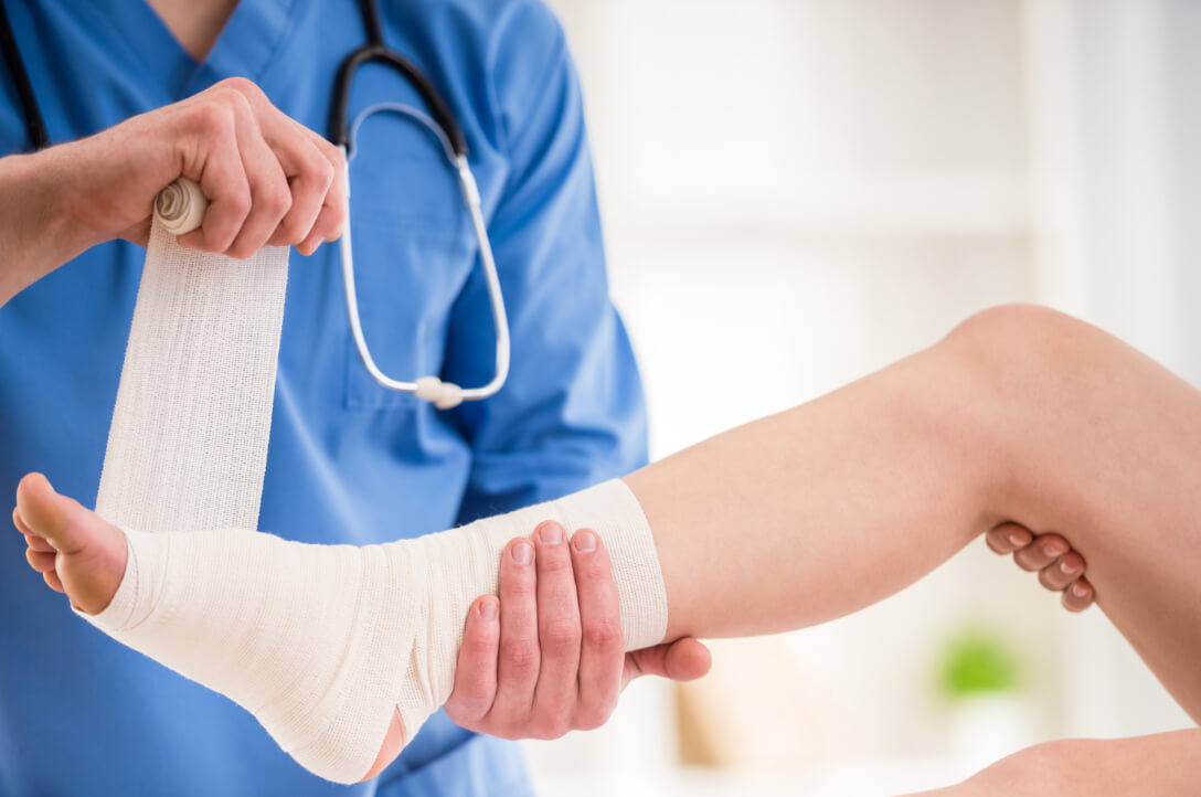 Orthopedic doctor wraps patient's injured foot