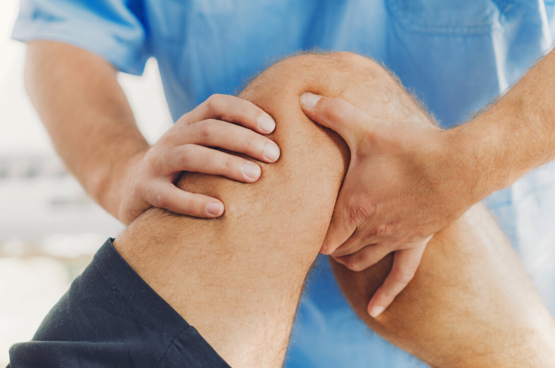 Orthopedic doctor examines patient's injured knee
