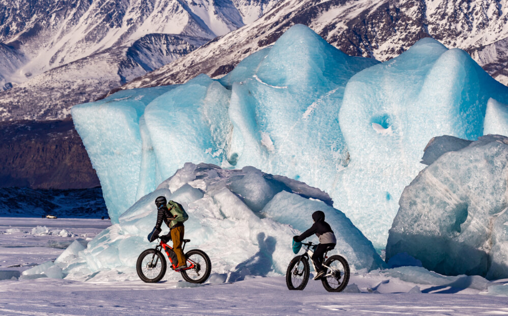 Orthopedic patients ride fat tire bikes next to a glacier in Alaska